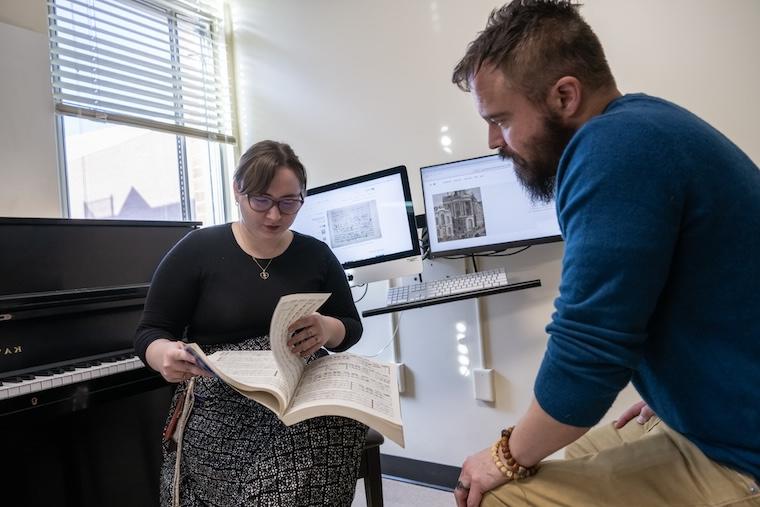 Dr. Jon McCollum and his student, Kaitlyn McCaffery, look over sheet music in a Washington College music room.